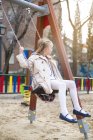 Улыбающаяся блондинка качается в парке — стоковое фото