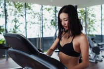 Asian woman setting race track in gym — Stock Photo