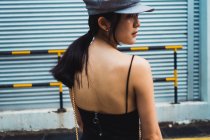 Elegante joven asiática mujer caminando en metal pared - foto de stock
