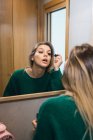 Casual woman applying mascara in bathroom — Stock Photo