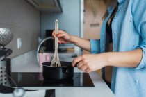 Mujer en sujetador y camisa cocinar el desayuno en la cocina - foto de stock