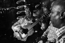Trio musicale cubano che recita in night club, ripresa in bianco e nero con lunga esposizione — Foto stock