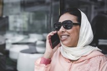 Mujer marroquí con hijab hablando por teléfono - foto de stock