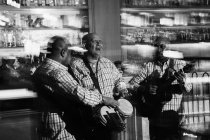 Trío musical cubano actuando en discoteca, plano blanco y negro con larga exposición - foto de stock