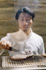 Chef preparando carne asada en restaurante - foto de stock