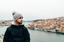 Молодий чоловік, що стоїть перед Старого міста з помаранчевого дах, порту, Португалія — стокове фото