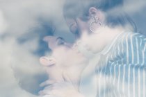 Sensual joven pareja besándose en ventana - foto de stock