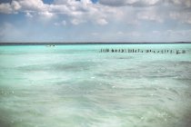 Rows of pillars in turquoise Caribbean sea in cloudy day, Mexico — Stock Photo