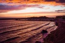 Драматическое небо на закате и город на побережье, Сардиния, Италия — стоковое фото