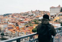 Männlichen Touristen Blick auf die Stadt mit orangefarbenen Dächern, porto, portugal — Stockfoto