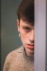 Sensual young man with freckles leaning on window — Stock Photo