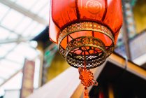 Red Asian lantern hanging on ceiling of pavilion — Stock Photo