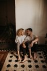 Homem romântico e mulher sentado no chão em casa e falando — Fotografia de Stock