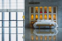 Innenaufnahme eines modernen geräumigen Schlafzimmers mit Steinboden und riesigem Bett gegen dekorativ beleuchtete Wand, PROPERTY in Chongqing — Stockfoto