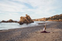 In forma giovane donna che esercita sulla spiaggia — Foto stock