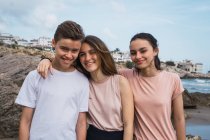 Portrait of smiling teenagers standing on seashore in summer — Stock Photo
