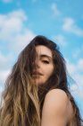 Sensuale giovane donna guardando la fotocamera sullo sfondo del cielo blu — Foto stock