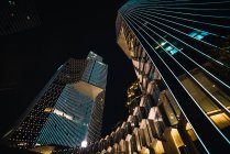 Rascacielos contemporáneos con paredes de vidrio en la noche, Singapur - foto de stock