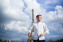 Усміхаючись червоні волосся кухар з ножами, що стоїть перед Ейфелеву вежу в Парижі — стокове фото