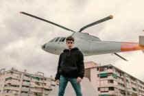 Schöner junger Mann steht vor Hubschrauberdenkmal an der Stadtstraße — Stockfoto