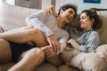 Весела молода пара розважається на дивані — стокове фото