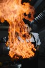 Взволнованный повар готовит фламбе на кухне ресторана — стоковое фото