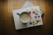 Cup of warm drink on book — Stock Photo