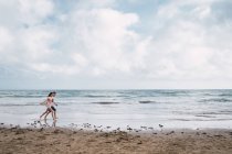 Teen ragazzo e ragazza a piedi sulla spiaggia in estate — Foto stock