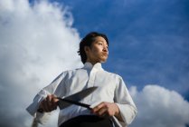 Chef japonês com facas na frente do céu azul com nuvens — Fotografia de Stock