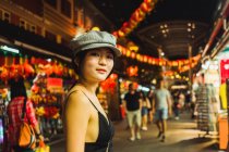 Portrait of young Asian woman in stylish clothes standing on street at night — Stock Photo