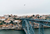 Bridge over channel and old city with orange roofs in overcast, Porto, Portugal — Stock Photo