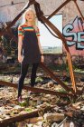 Sensual young woman standing in grunge backyard — Stock Photo