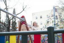 Усміхнена блондинка гойдається в парку — стокове фото