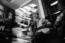 Trio musical cubain se produisant dans une boîte de nuit, plan noir et blanc avec une longue exposition — Photo de stock