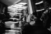Trio musical cubano se apresentando em boate, tiro preto e branco com longa exposição — Fotografia de Stock