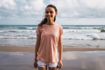 Портрет усміхненої дівчини-підлітка, що стоїть на пляжі — стокове фото