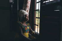 CAMERUN - AFRICA - 5 APRILE 2018: Bella donna africana che guarda attraverso la finestra — Foto stock