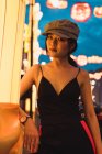Portrait de jeune femme asiatique à la mode debout dans la ville illuminée dans la soirée — Photo de stock