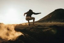 Hombre saltando en tierra seca - foto de stock