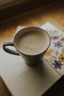 Чашка теплого напитка по книге — стоковое фото
