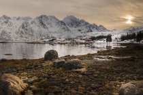 Bucht und felsige Berge mit Schnee bedeckt unter bewölktem Himmel, hamnoy, Norwegen — Stockfoto