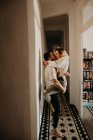Пристрасний чоловік і жінка обіймаються і цілуються біля стіни в залі вдома — стокове фото