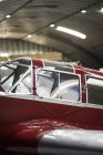Red carcass of small vintage airplane in hangar — Stock Photo