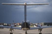Aeronaves situadas en tierra del aeródromo civil de la ciudad contra el cielo nublado - foto de stock