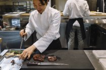 Chef preparando prato com pauzinhos no restaurante — Fotografia de Stock