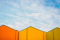 Яркие современные красочные дома и облачно-голубое небо — стоковое фото