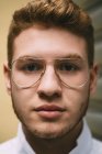 Porträt eines rothaarigen Mannes mit stylischer Brille, der in die Kamera blickt — Stockfoto