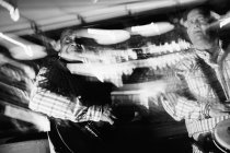 Музиканти грають на гітарі та барабанах у нічному клубі, чорно-білий знімок з тривалим експозицією — стокове фото