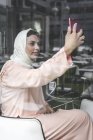 Элегантная марокканская женщина с хиджабом и типичным арабским платьем делает селфи — стоковое фото