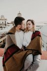 Paar umarmt sich mit Decke auf Terrasse in der Altstadt — Stockfoto